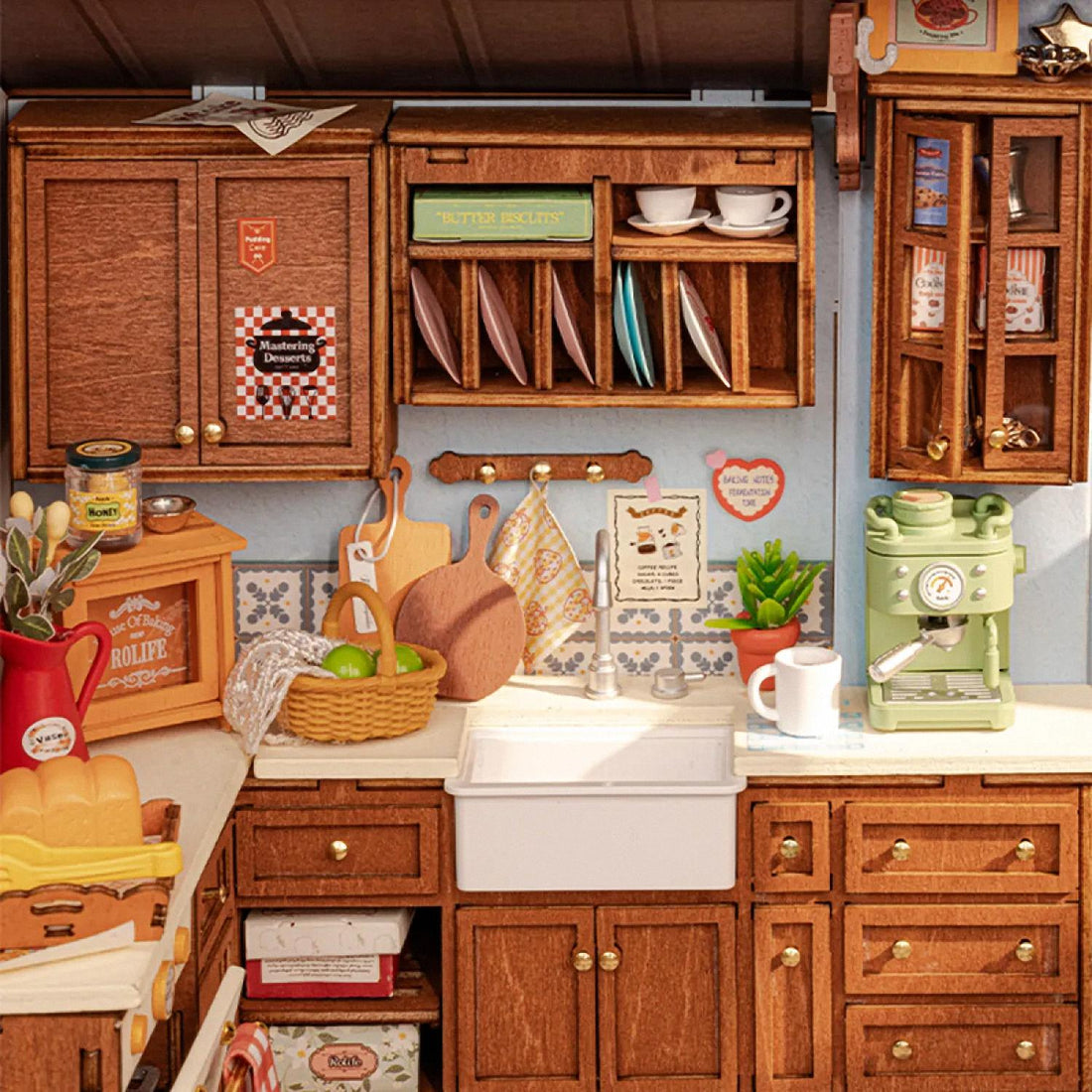 Detailed model of a miniature kitchen with various appliances and furniture on a wooden surface.