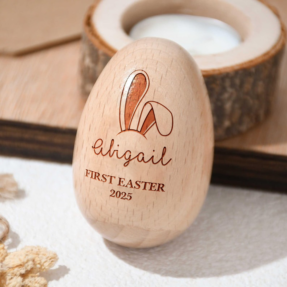 Custom wooden Easter egg featuring engraved bunny ears, the name Abigail, First Easter 2025, and a rustic wooden tealight