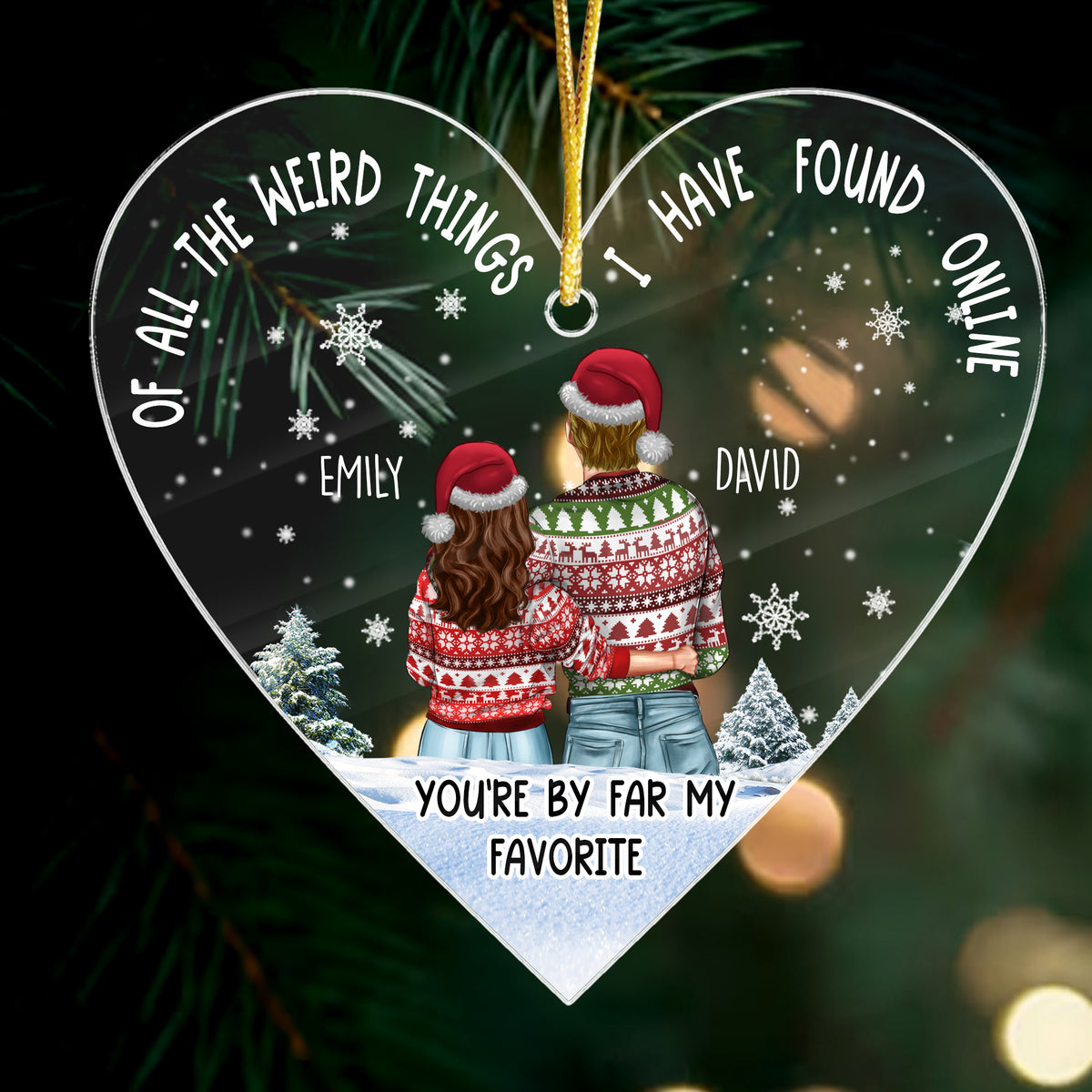 Close-up of a heart-shaped clear acrylic ornament showing a couple in festive sweaters and Santa hats against a snowy