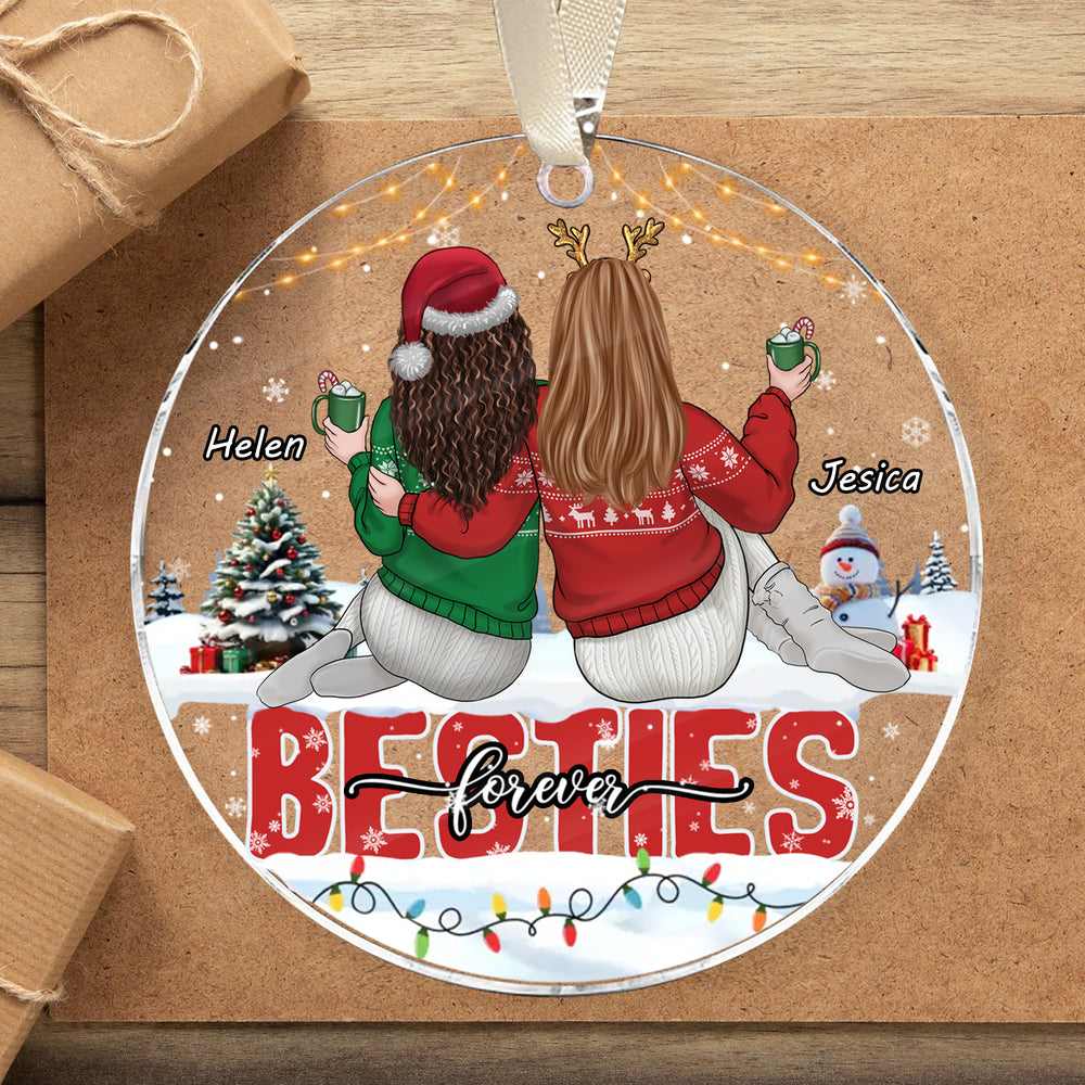 Round acrylic besties forever ornament with names Helen and Jesica, set against a brown gift box with string.