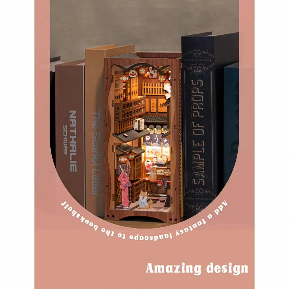An illuminated Japanese alley miniature diorama placed on a bookshelf between books.