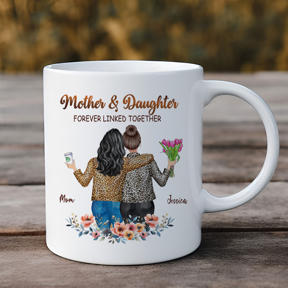 Personalized white ceramic mug for mom featuring an illustration of a mother and daughter with custom names on a wooden