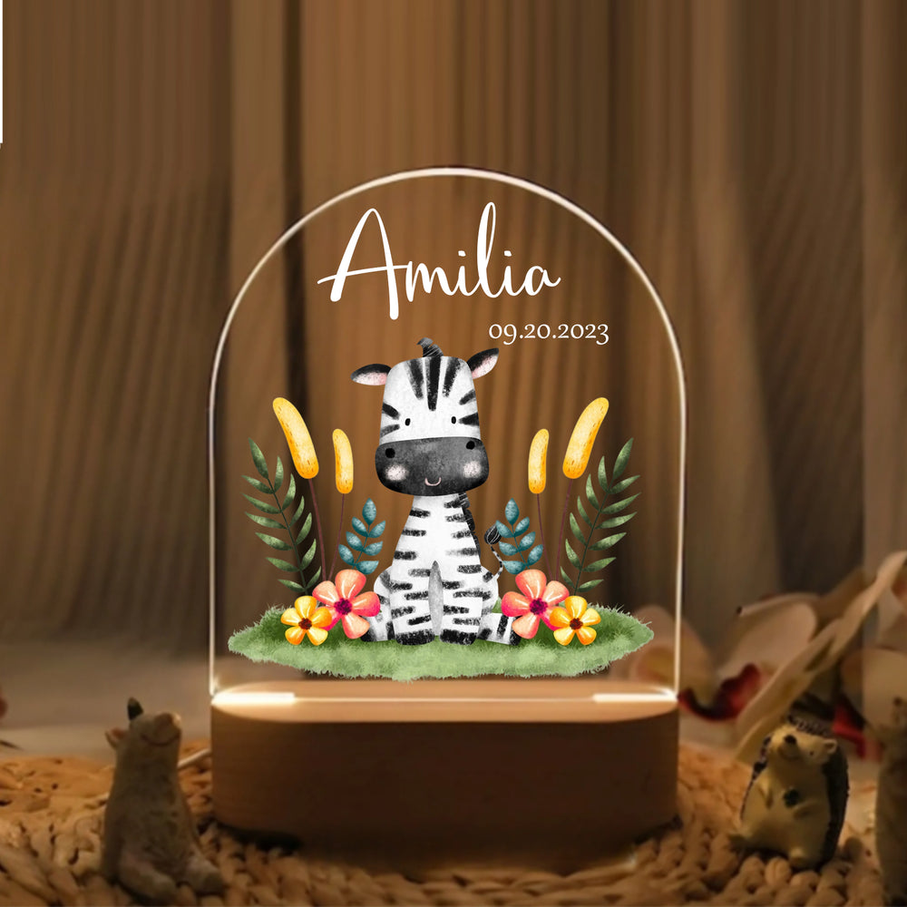 Adorable LED night lamp featuring a cute zebra illustration, name, and date on clear acrylic, sitting on a textured surface.