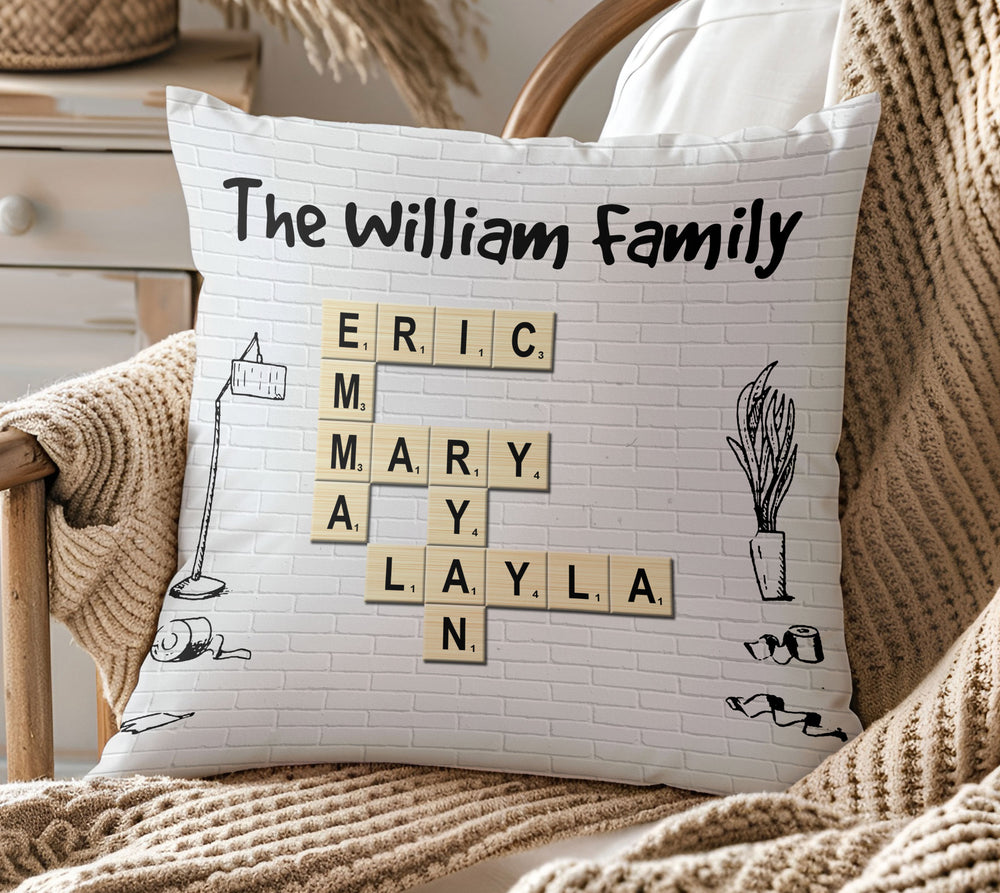 Personalized family pillow with crossword scrabble letter tiles and cartoon doodles on a white brick background.