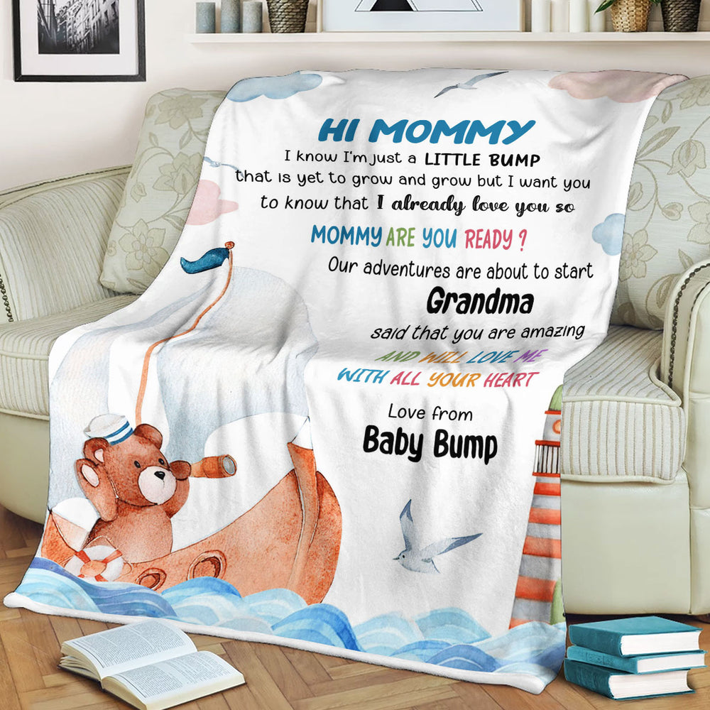 Custom baby bump throw blanket with watercolor nautical design draped over a cozy living room sofa.