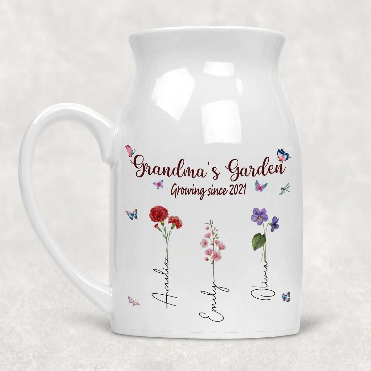Personalized white ceramic flower vase with Grandma's Garden design, birth flowers, and names against a grey background.