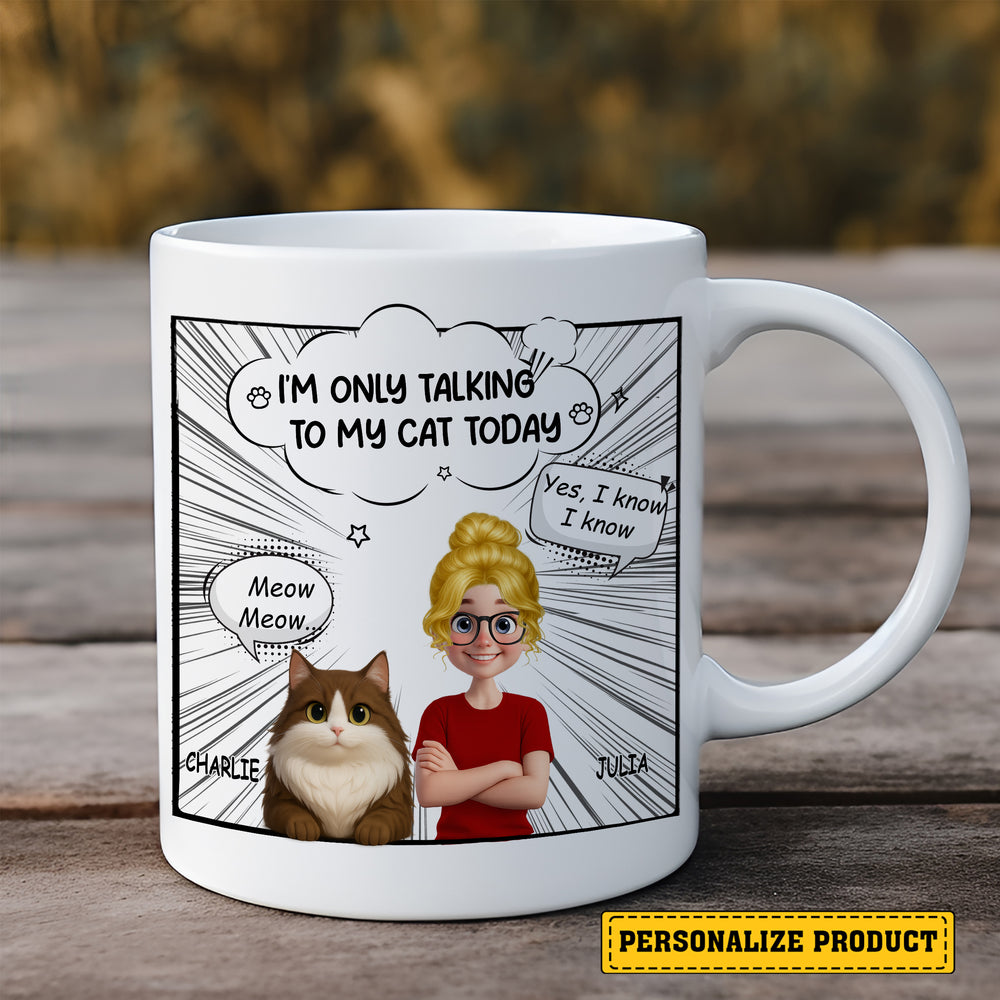 A white ceramic mug with a personalized comic design featuring a brown and white cat and a woman, standing on a wooden