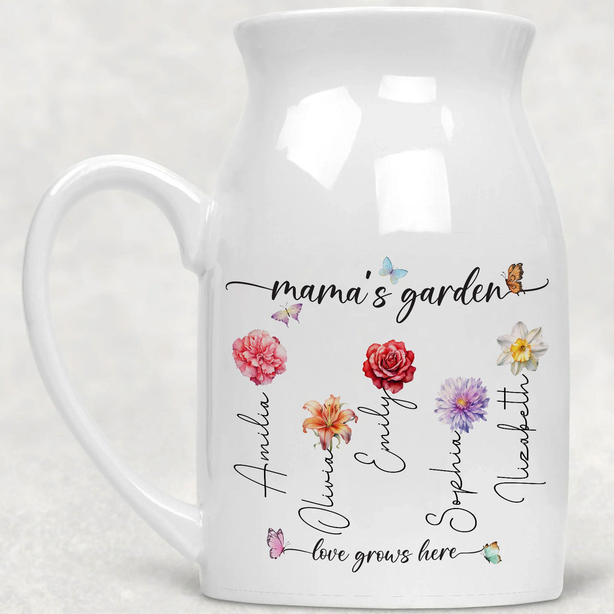 White ceramic flower vase with side handle featuring custom birth flowers, names, butterflies and Nana's garden design.