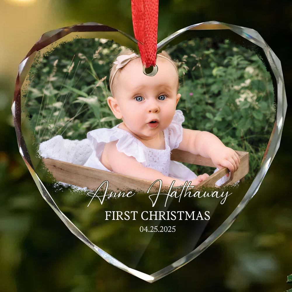 Close-up of a bevel-edged heart glass ornament showcasing a baby's first Christmas photo keepsake with custom text.