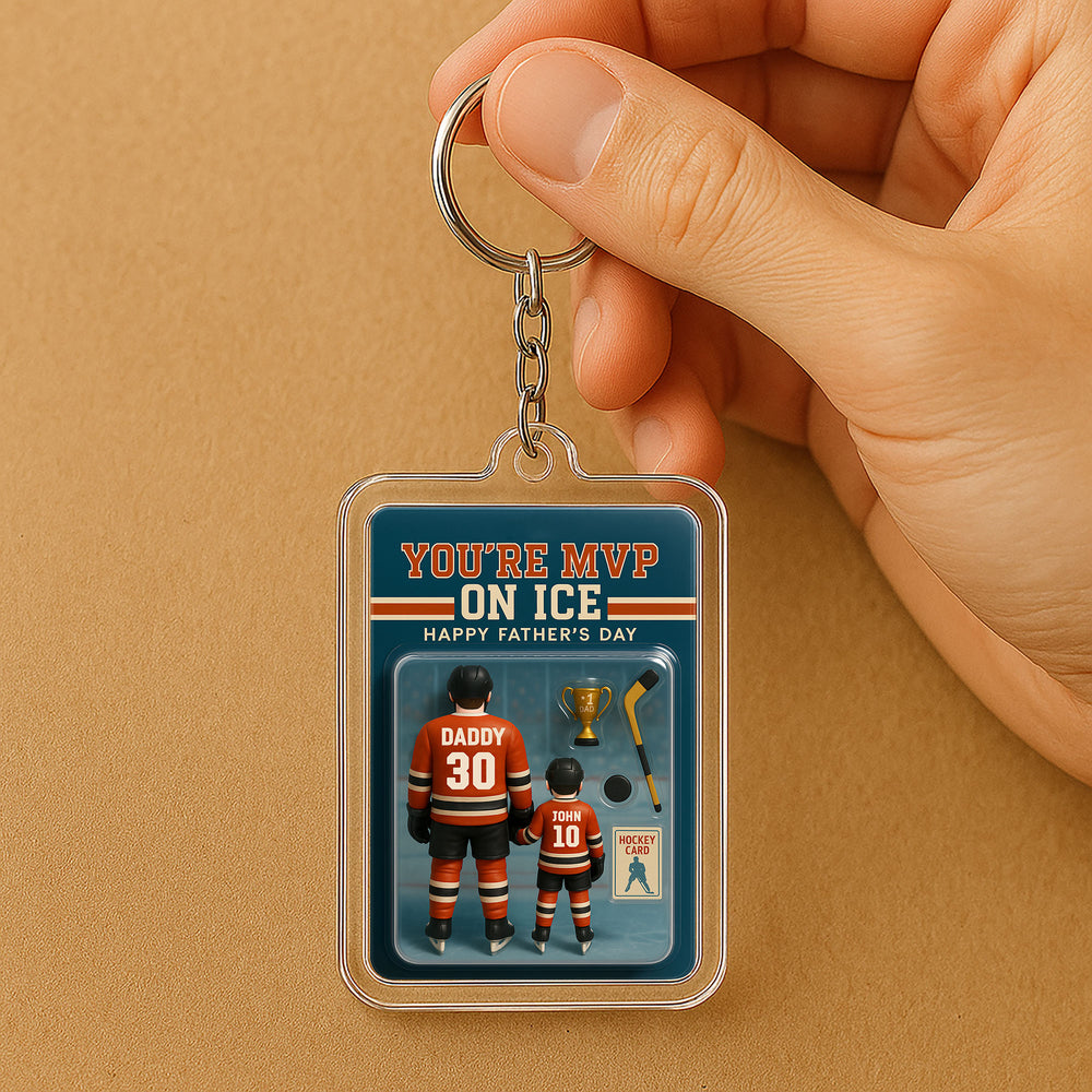 Personalized hockey dad acrylic keychain held in hand, featuring orange and black jerseys with DADDY 30 and JOHN 10 against a