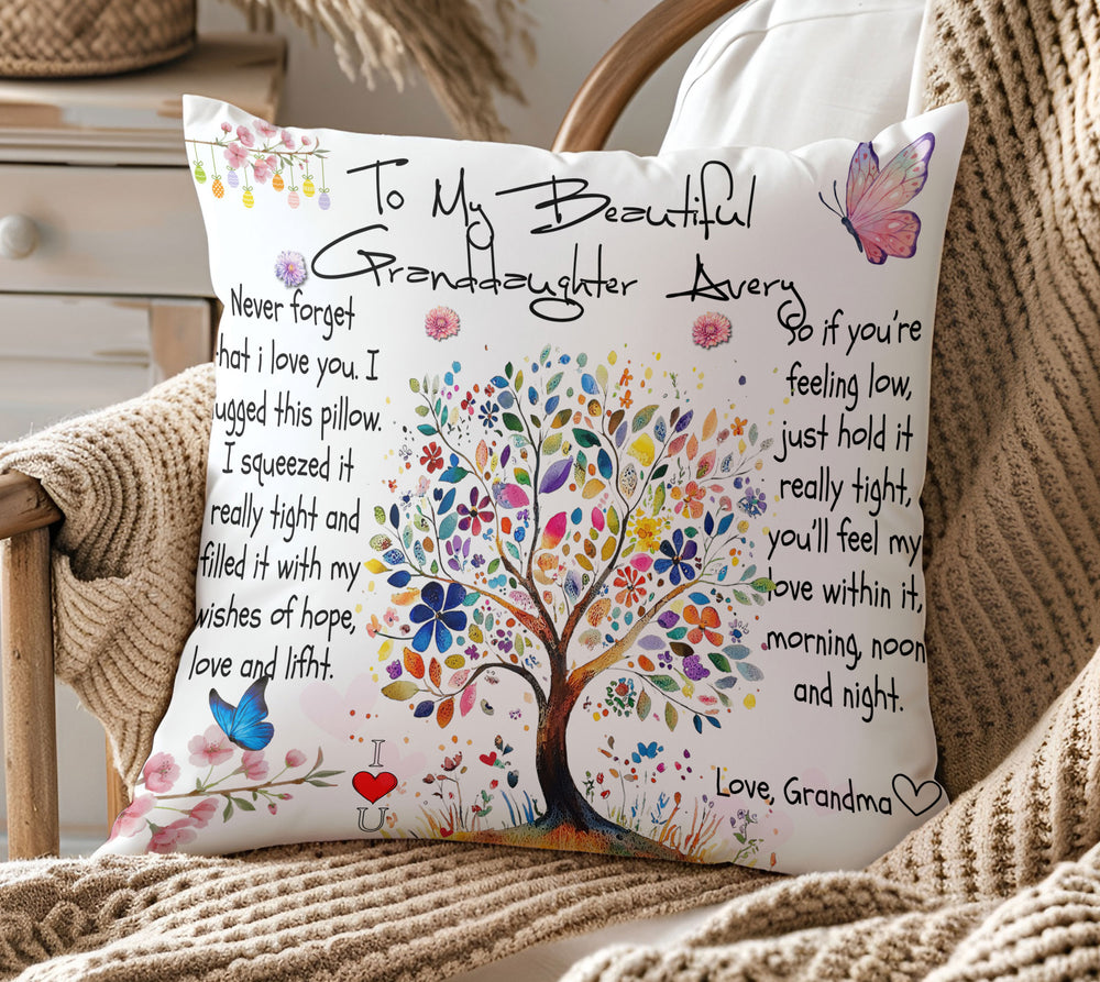 Personalized To My Granddaughter pillow featuring a vibrant floral tree, resting on a wooden armchair with a throw.