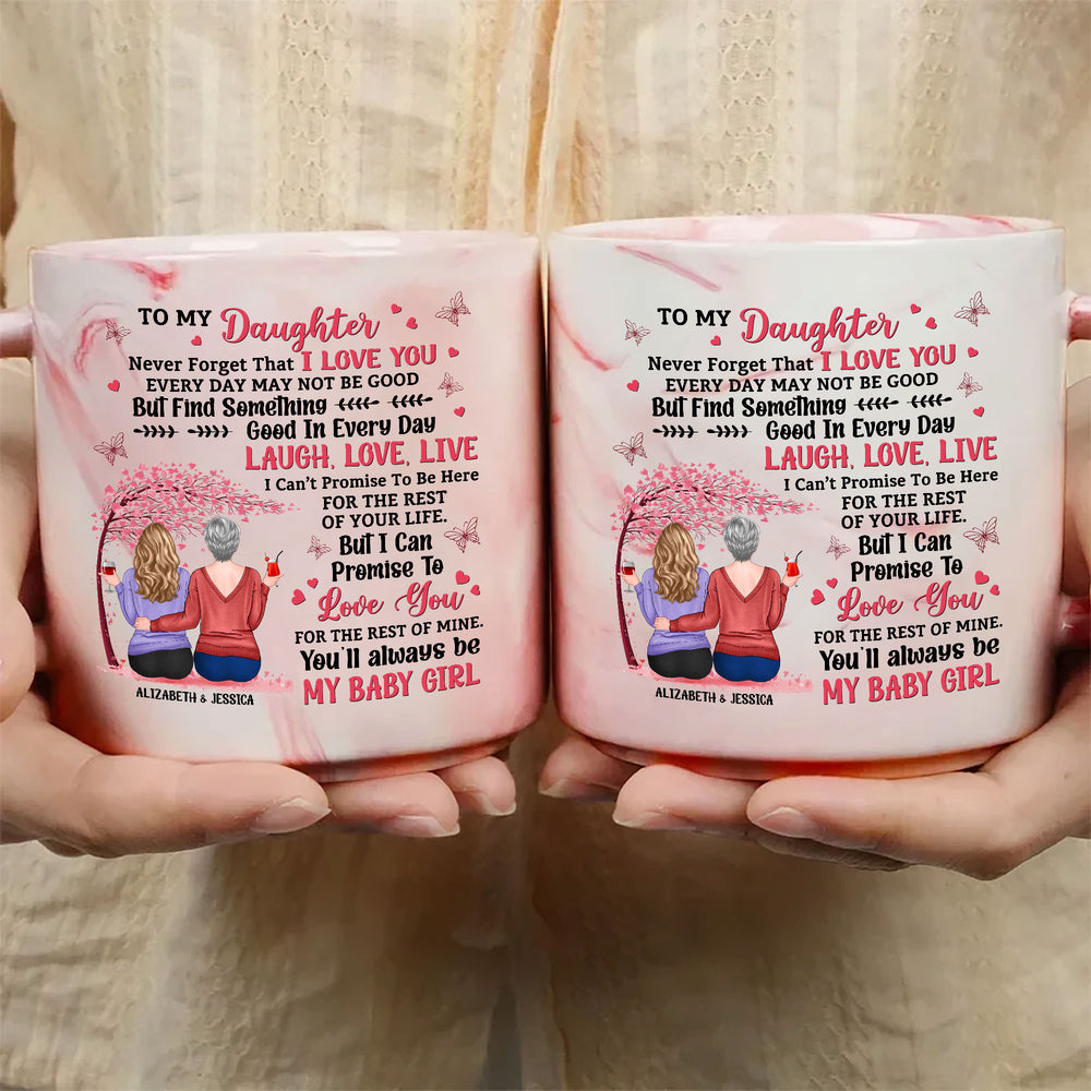 Two pink marble mugs held up showing a customized mother and daughter illustration under a cherry tree with text.