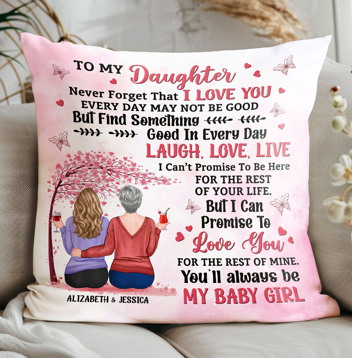 Pink throw pillow featuring a mother and daughter quote with illustrated women drinking wine under a pink tree on a couch.