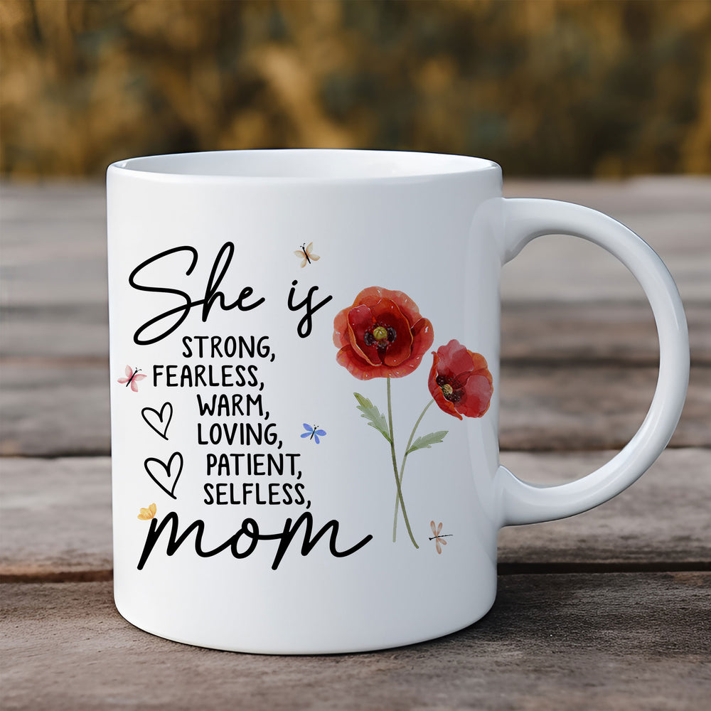 Personalized floral mom mug standing upright on a rustic wooden surface outdoors.