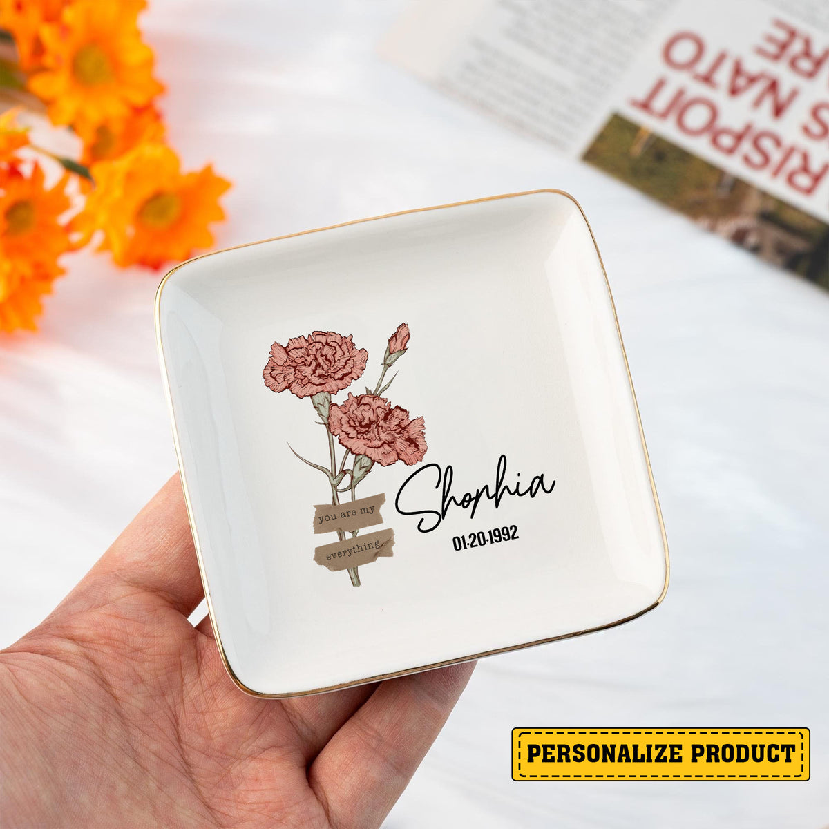 Square white ceramic ring dish with gold rim, pink carnation illustration, and custom name Sophia with date 01-20-1992.
