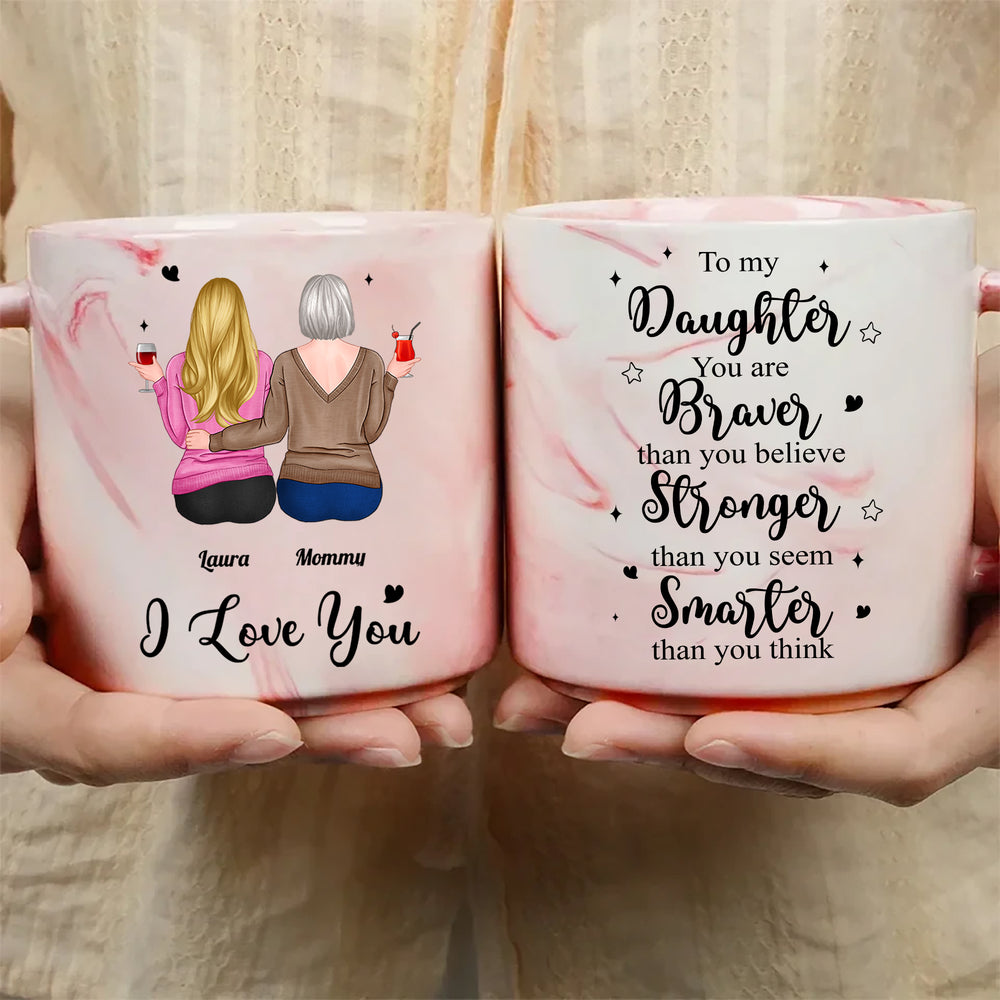 Two pink marble mugs held in hands showing daughter and mother illustration on one side and inspirational quote on the other.