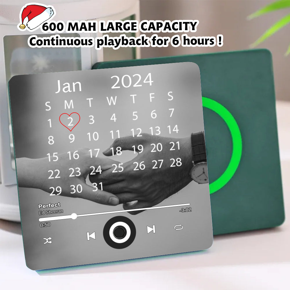 Green square fridge magnet featuring a calendar with a heart on Jan 2nd, a couple's hands, and music player interface.