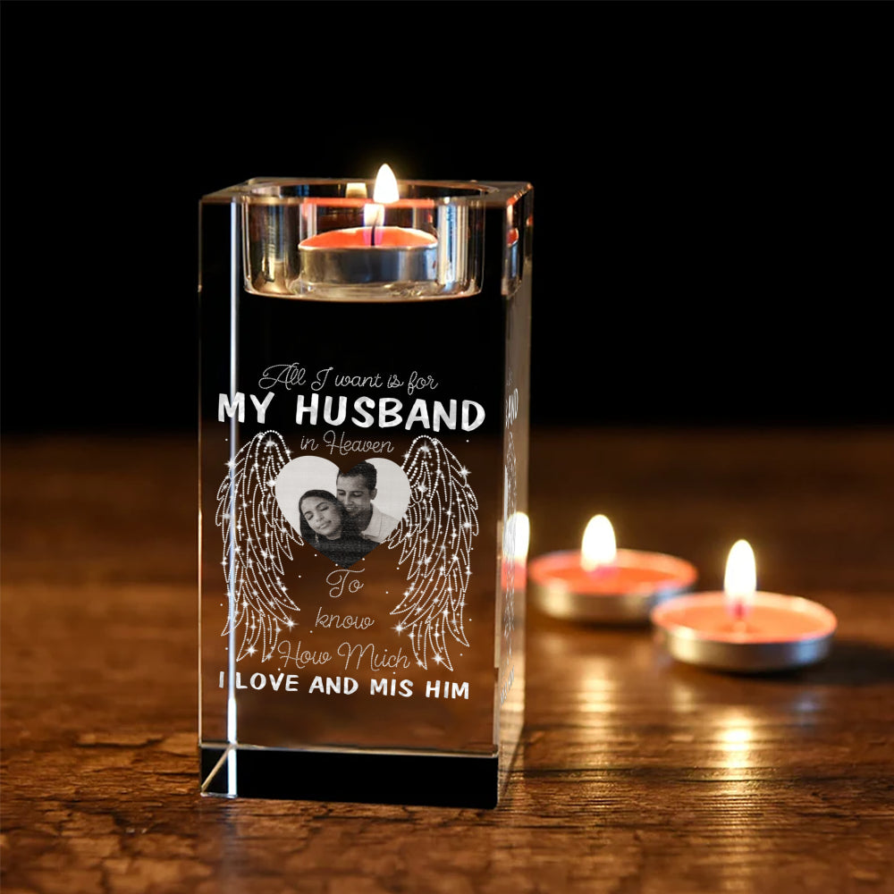 Lit memorial crystal candle holder with engraved heart photo and angel wings on a dark wood table with tea lights.