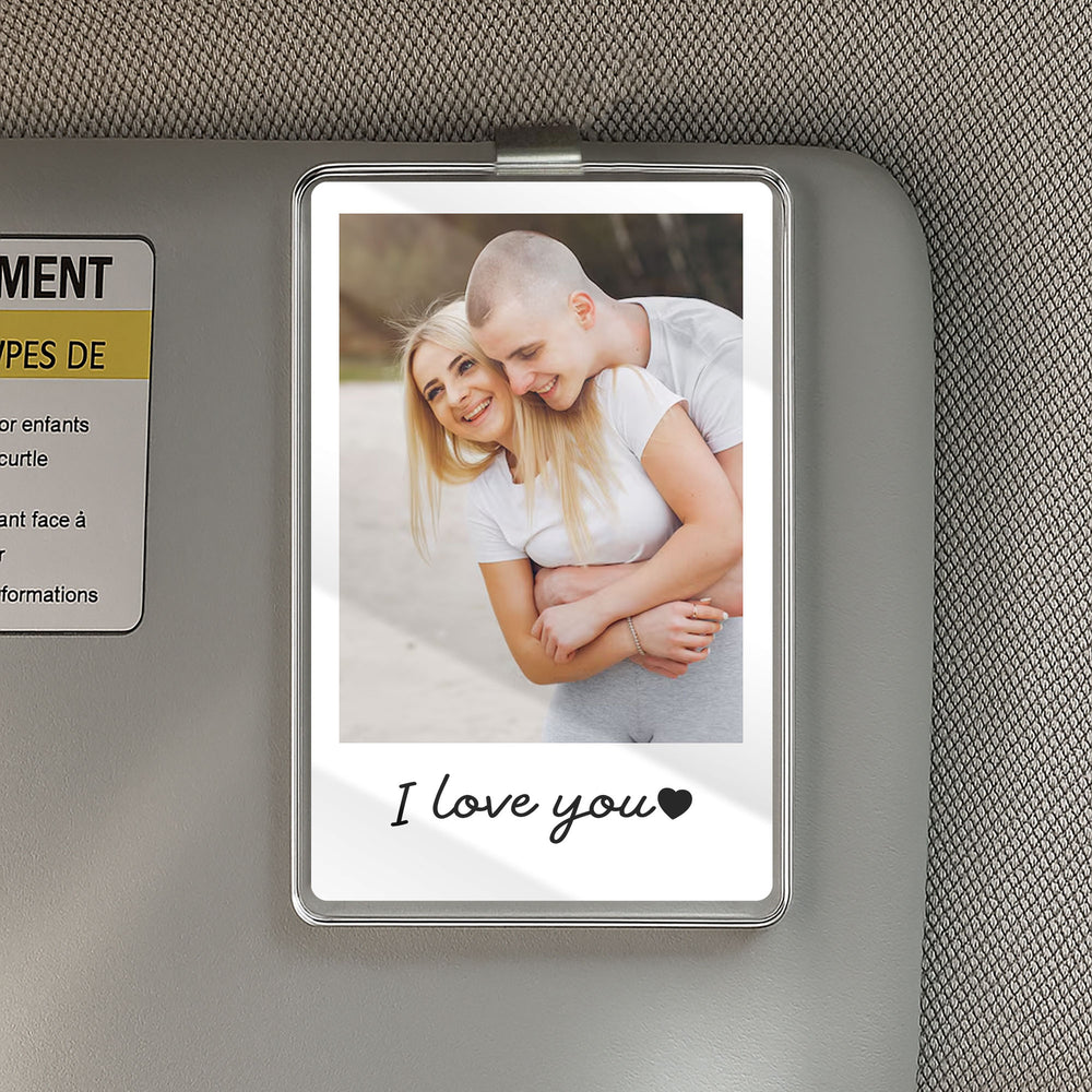 Personalized photo car visor clip attached to a gray sun visor, displaying a hugging couple and the text I love you.