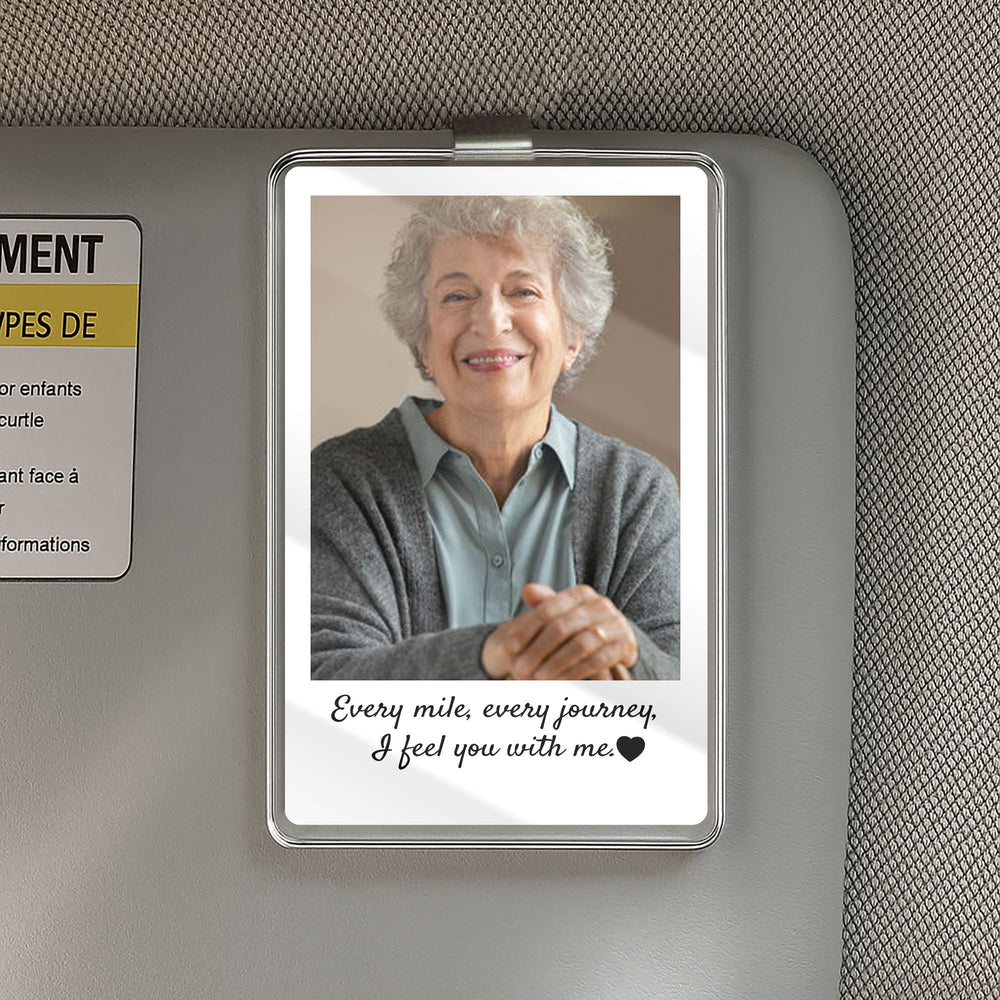 Custom photo car visor clip attached to a sun visor featuring an older woman in a grey cardigan and remembrance text.