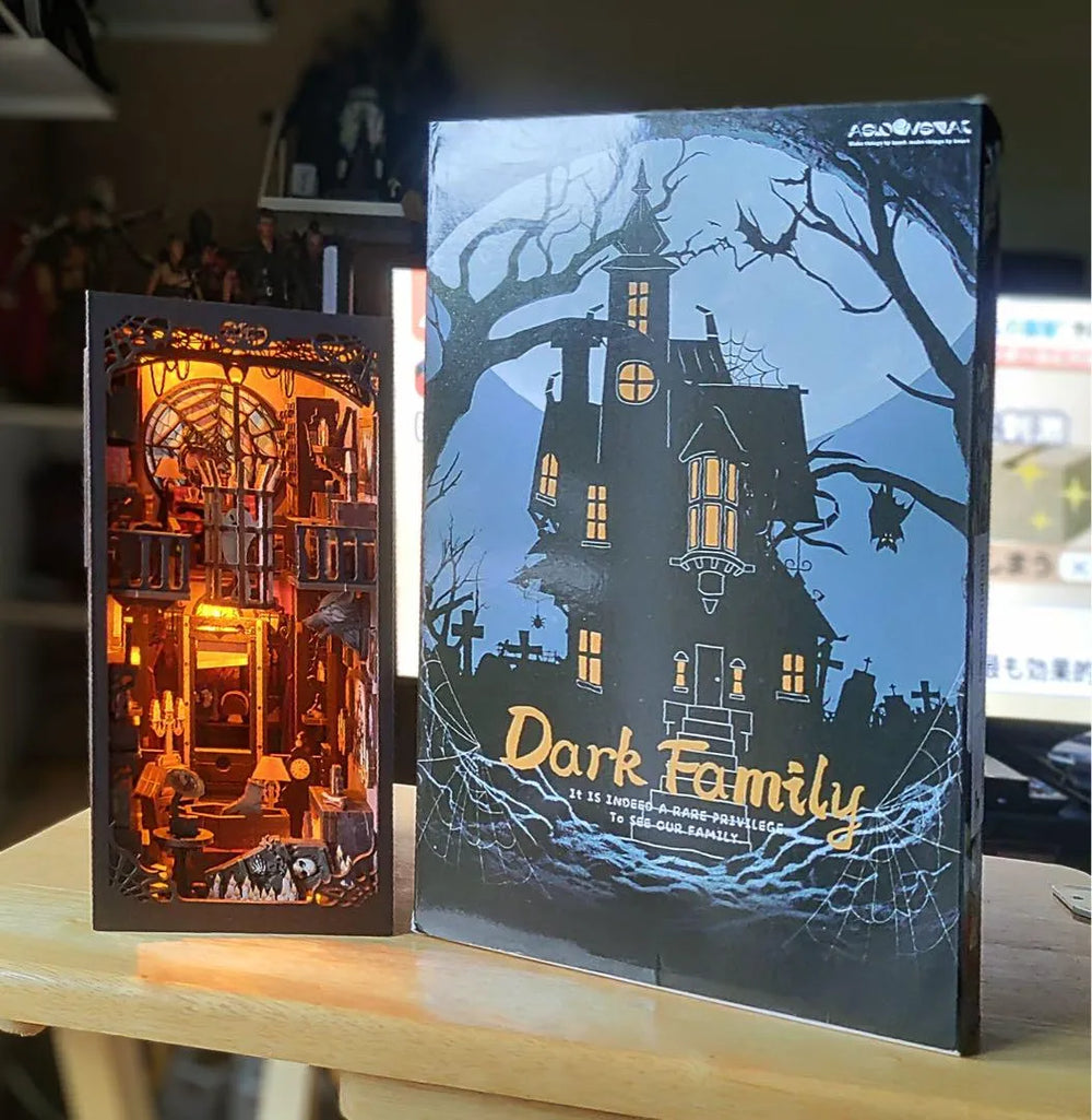 DIY book nook kit beside its matching Dark Family haunted house storage box packaging.