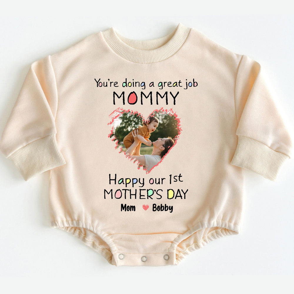 Beige long sleeve baby romper featuring a personalized photo within a heart design and Happy our 1st Mother's Day text