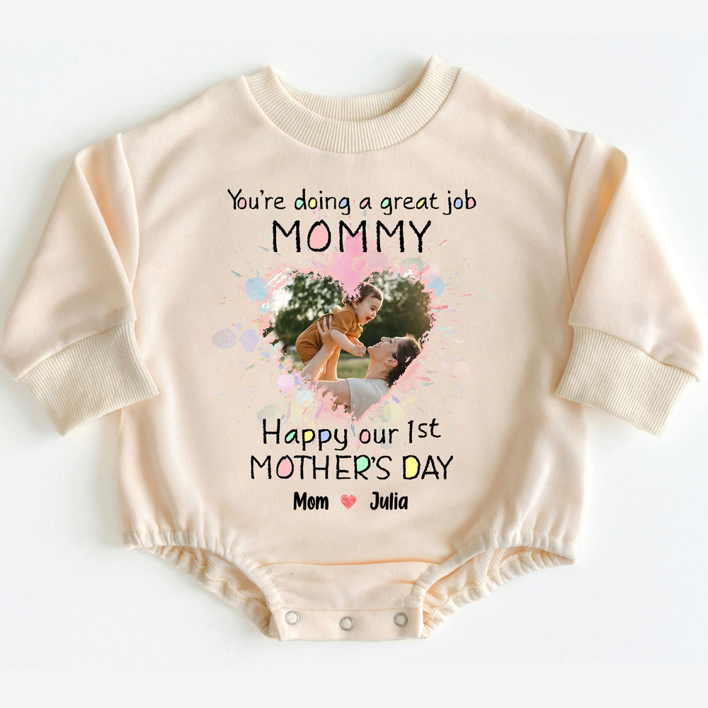 Beige long-sleeve baby romper featuring a watercolor heart photo print, text reading You're doing a great job Mommy Happy our