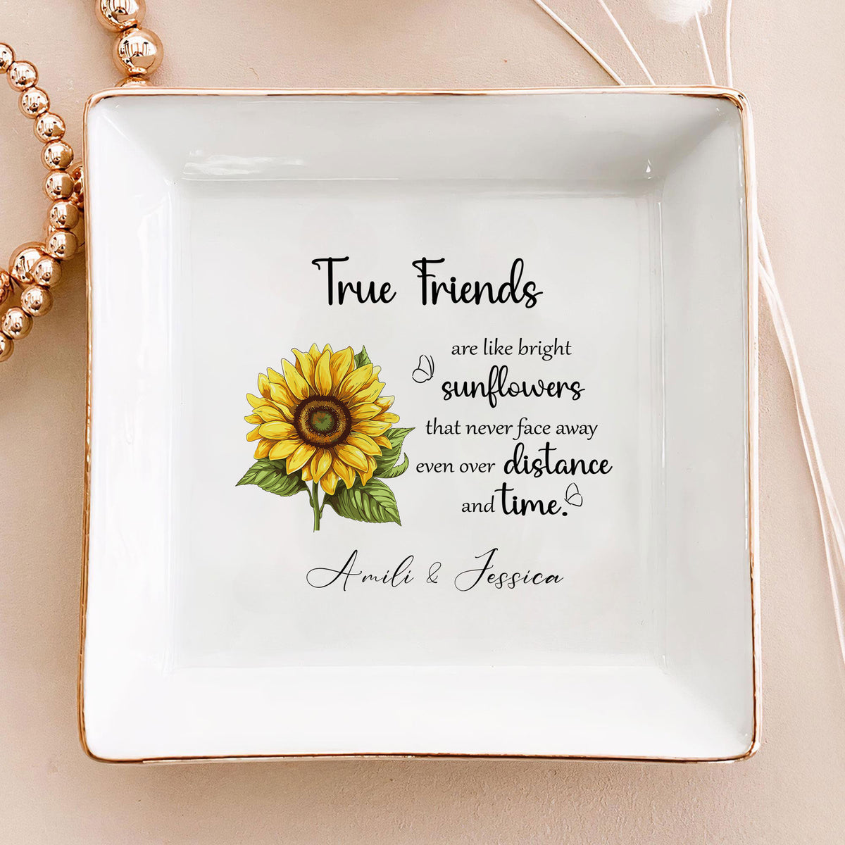 Top view of white square ceramic jewelry dish with gold edges, sunflower print, and custom names.