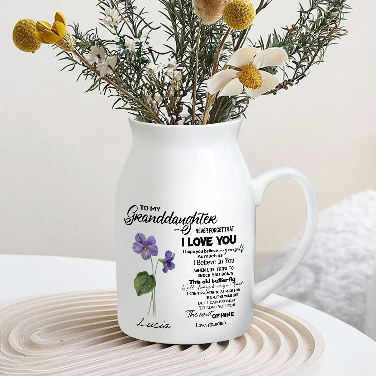 Personalized granddaughter flower vase filled with dried floral arrangement displayed on a neutral surface.
