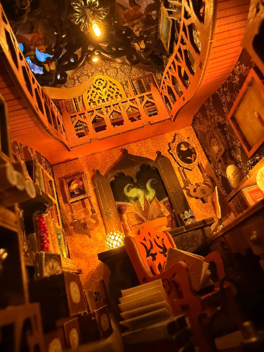 Interior angle of the Magic Library Book Nook Kit revealing detailed miniature bookshelves, a hanging lantern, and flying