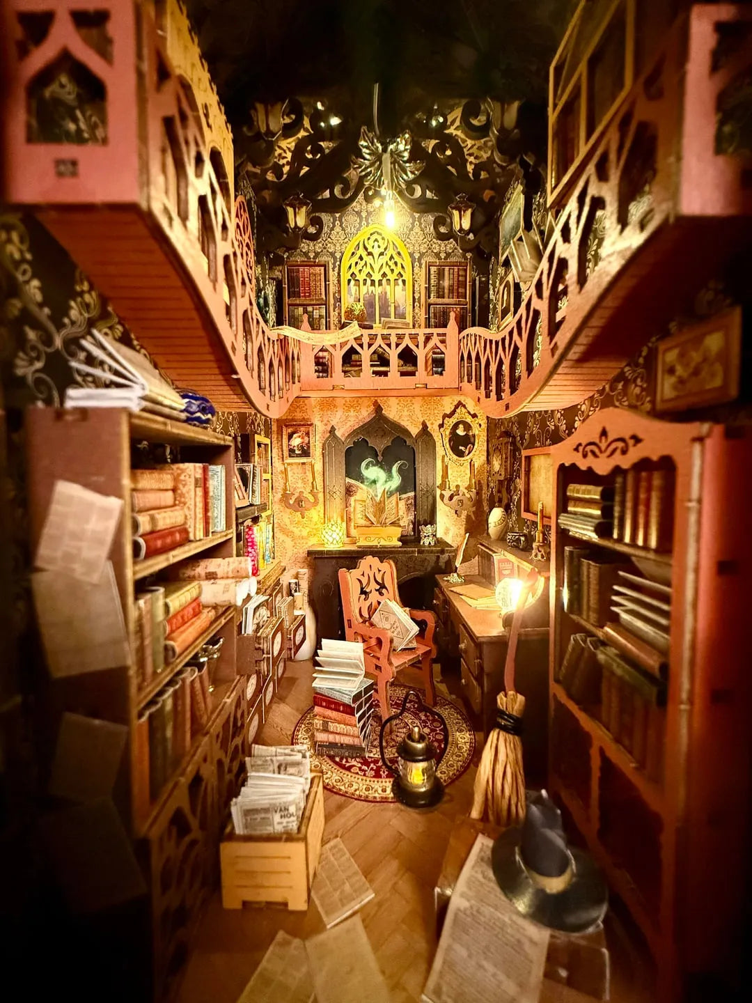 Wide interior view of the assembled nook book kit showing both bookshelves, the mezzanine balcony, cozy chair, and scattered