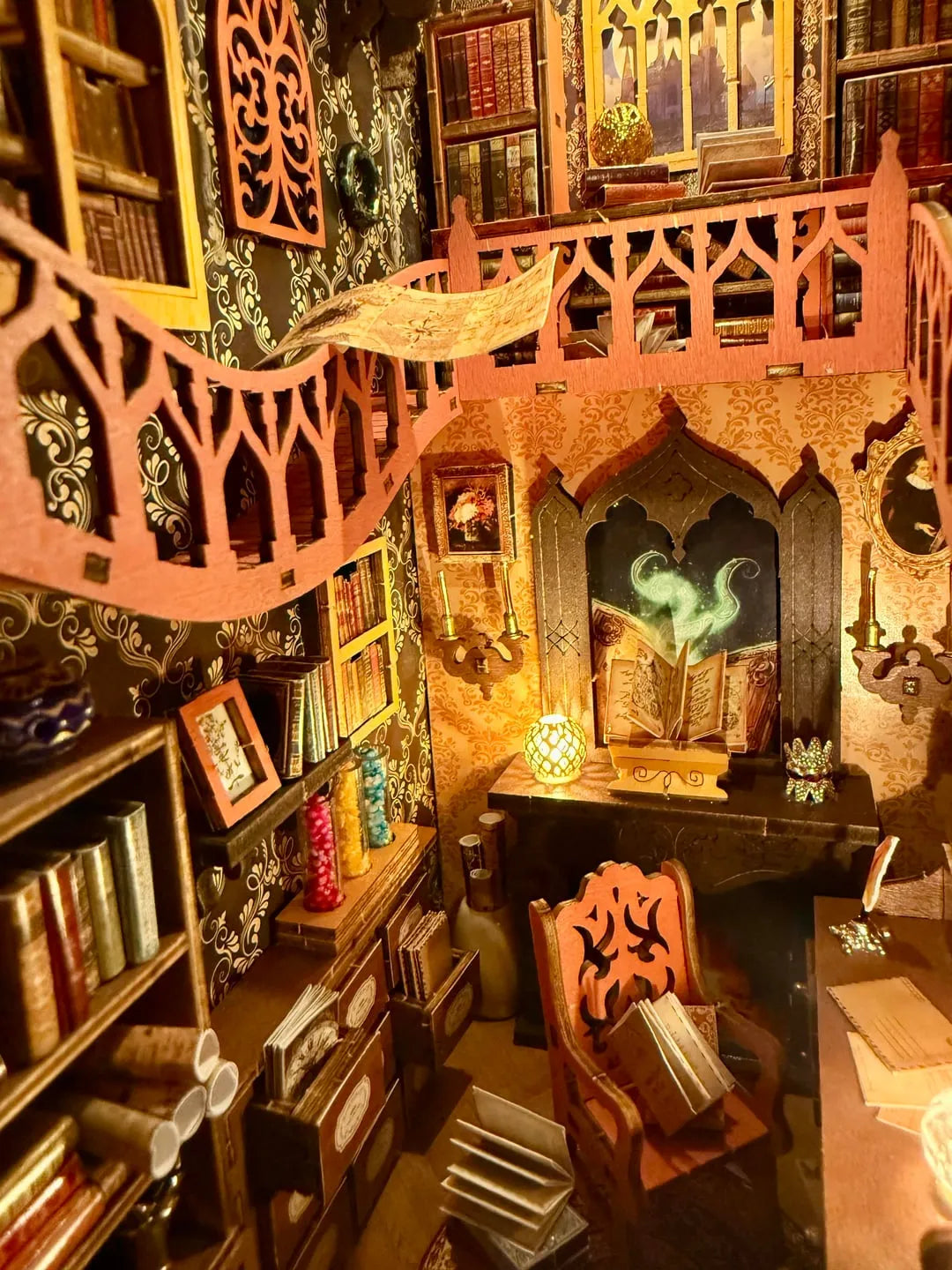 Top down interior perspective of the book nook puzzle highlighting the detailed desk setup, open spellbook, and miniature