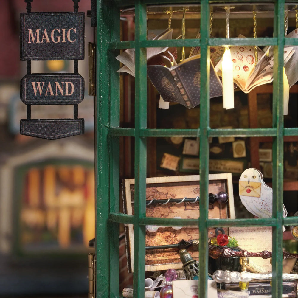 Close-up of Magic Wand Shop Nook Book Kit window with mini wands, books, and an owl holding a letter.