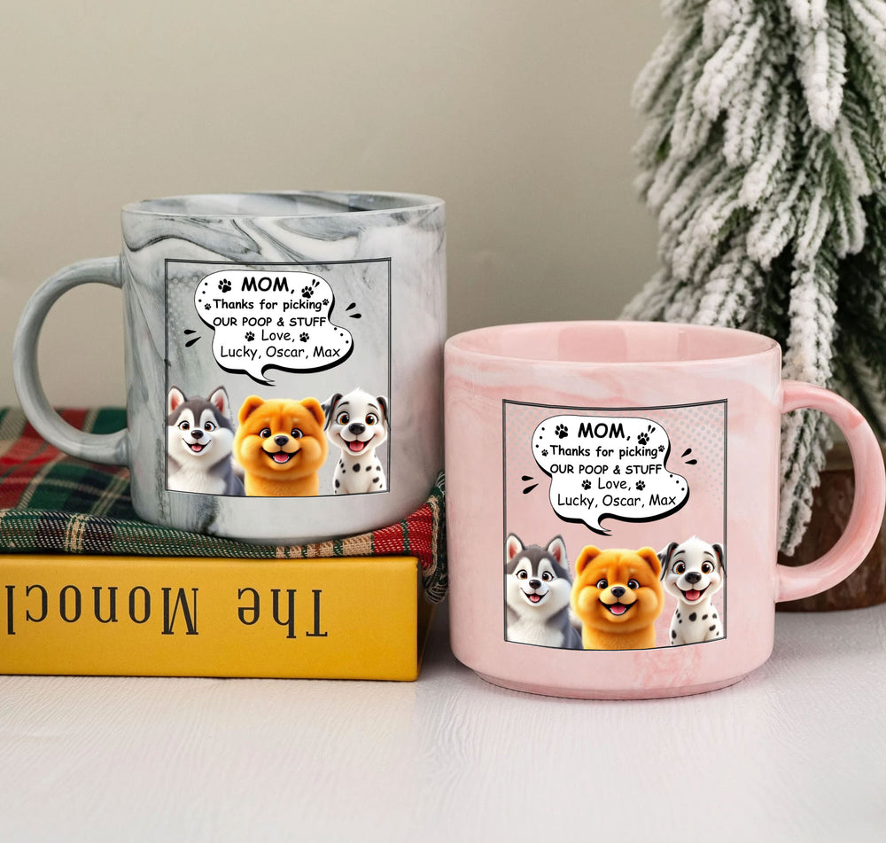 Grey and pink marble ceramic mugs sitting together on a table next to a small book and a decorative mini evergreen tree.
