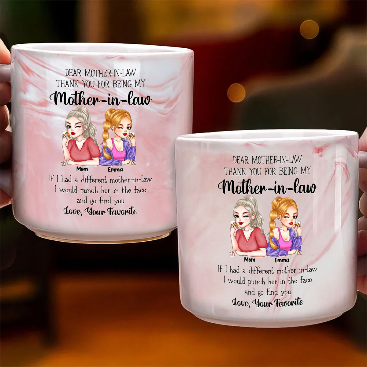 Two pink personalized marble mugs displaying humorous text and cartoon portraits against a warm blurred background.