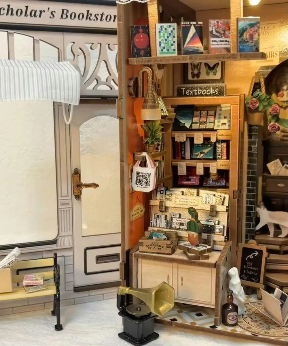Close-up interior of miniature library book nook showing tiny textbooks, shelves, cute white cat figure, and a miniature